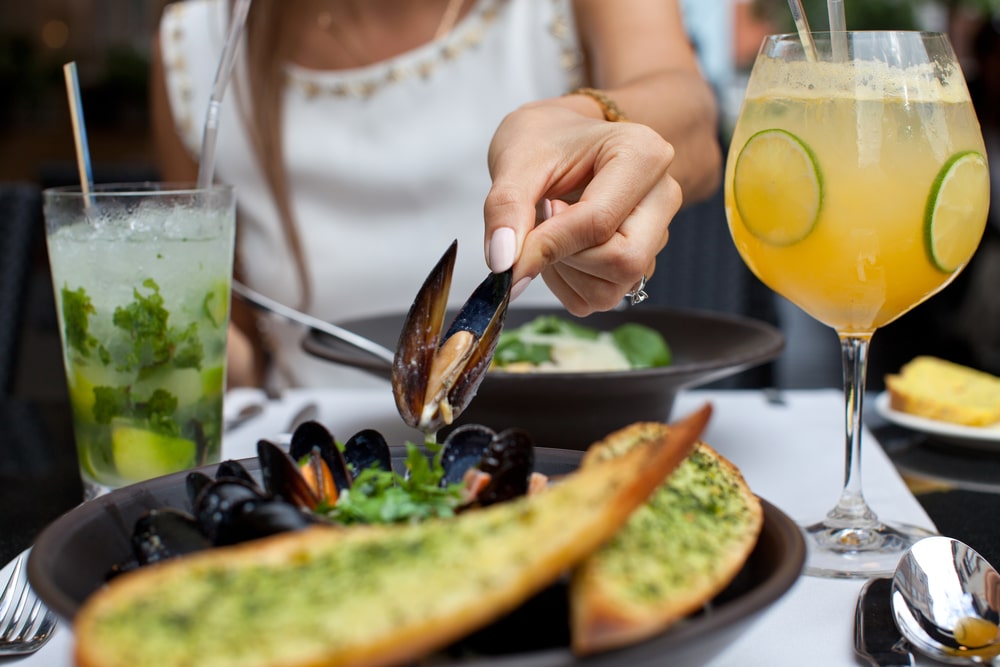 Woman eating muscles at the top St. Augustine Seafood Restaurants