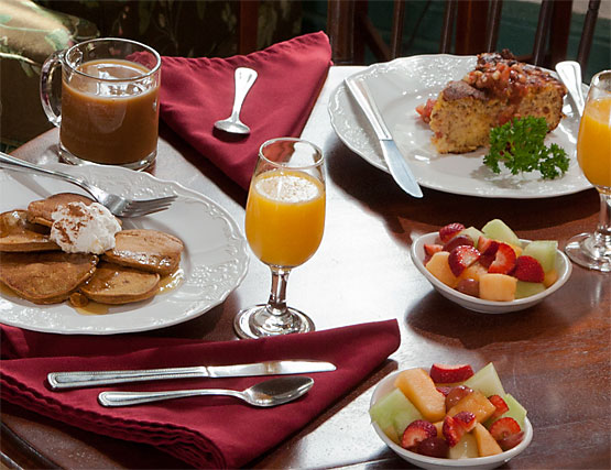 Breakfast plates with pancakes, quiche, fresh fruit